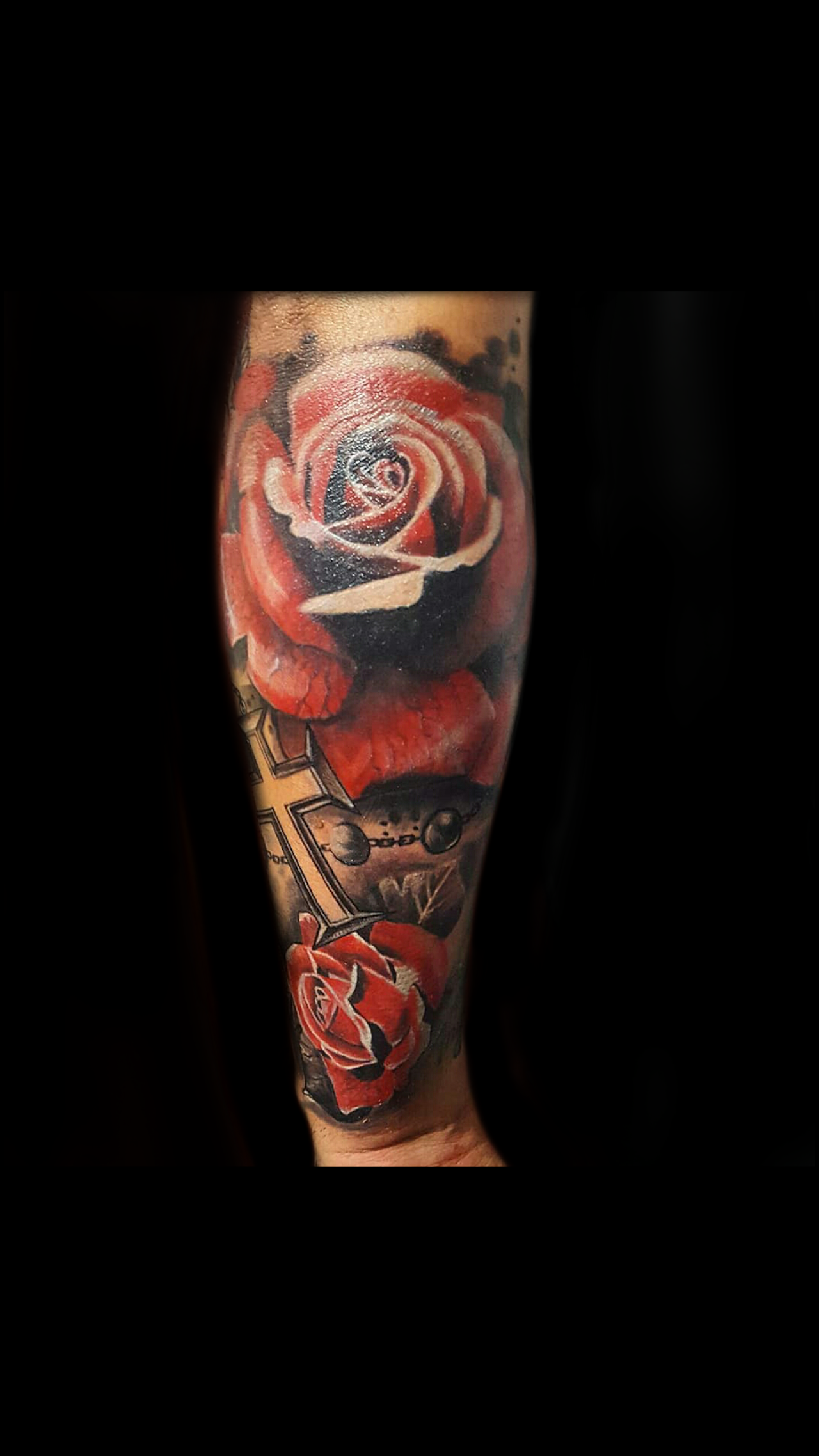 Tatuaje realista de rosa roja y cruz en antebrazo